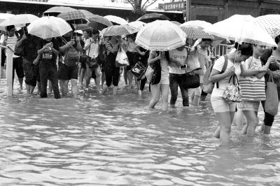 8月24日，在上海青浦区地铁2号线徐泾东站附近，市民冒雨前行。新华社发