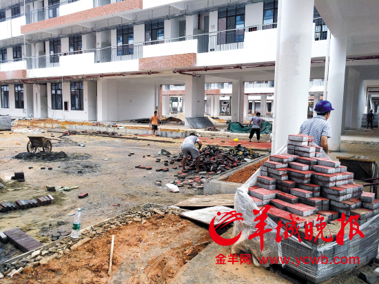 工人们在教学楼之间铺装地面