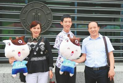 9月12日,四川大学江安校区,彭超和父母在校园门口合影。