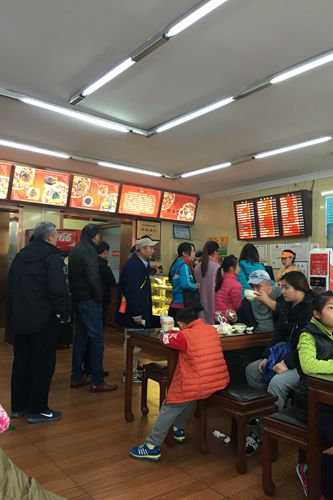 中午一点左右的包子铺，依然有不少人排队等着吃饭。顾客供图