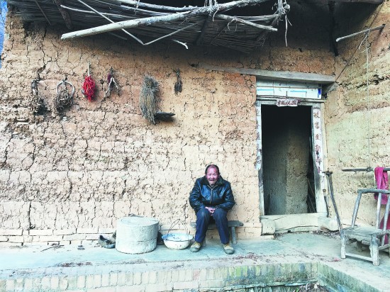 一个失去儿子的老人坐在房前